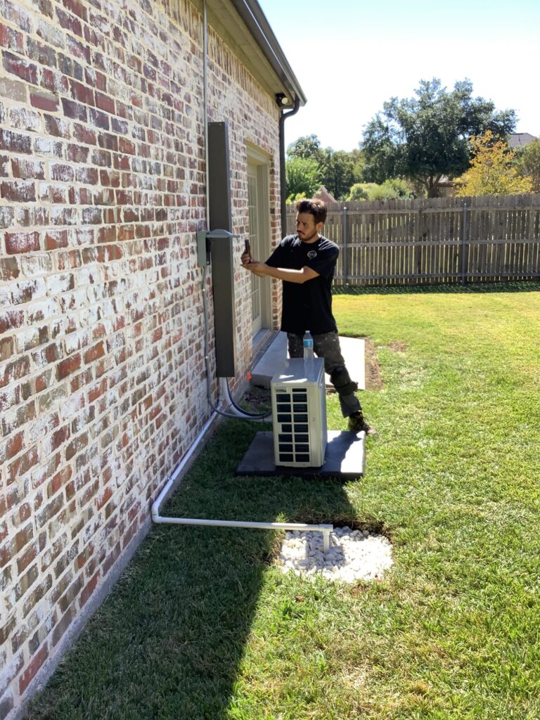 A worker tuning up an ac unit in preparation for warmer months