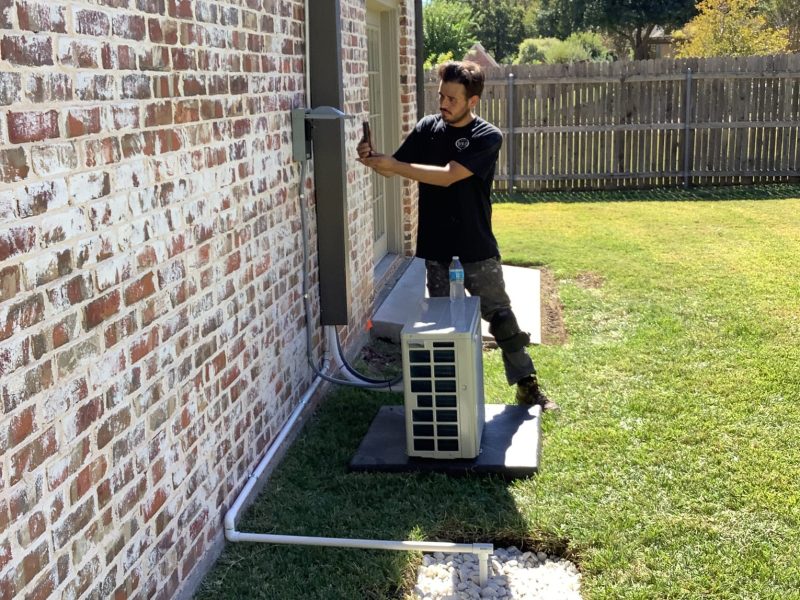 A worker tuning up an ac unit in preparation for warmer months